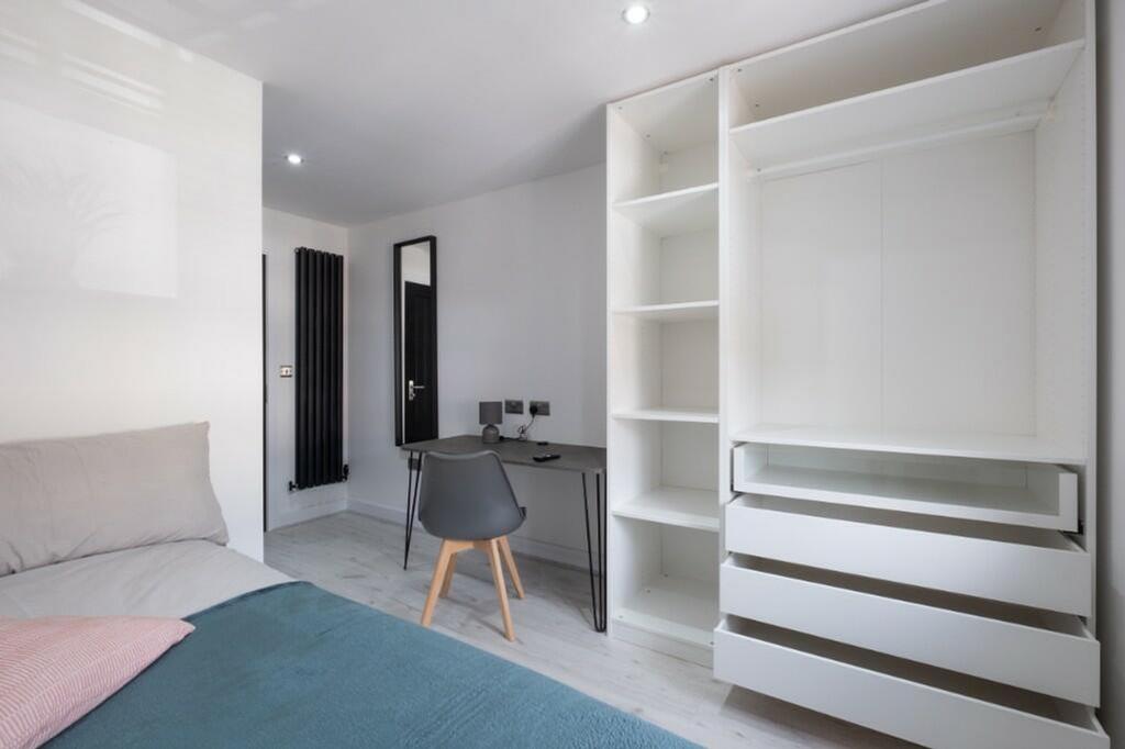 A stylish and modern double bedroom featuring a...