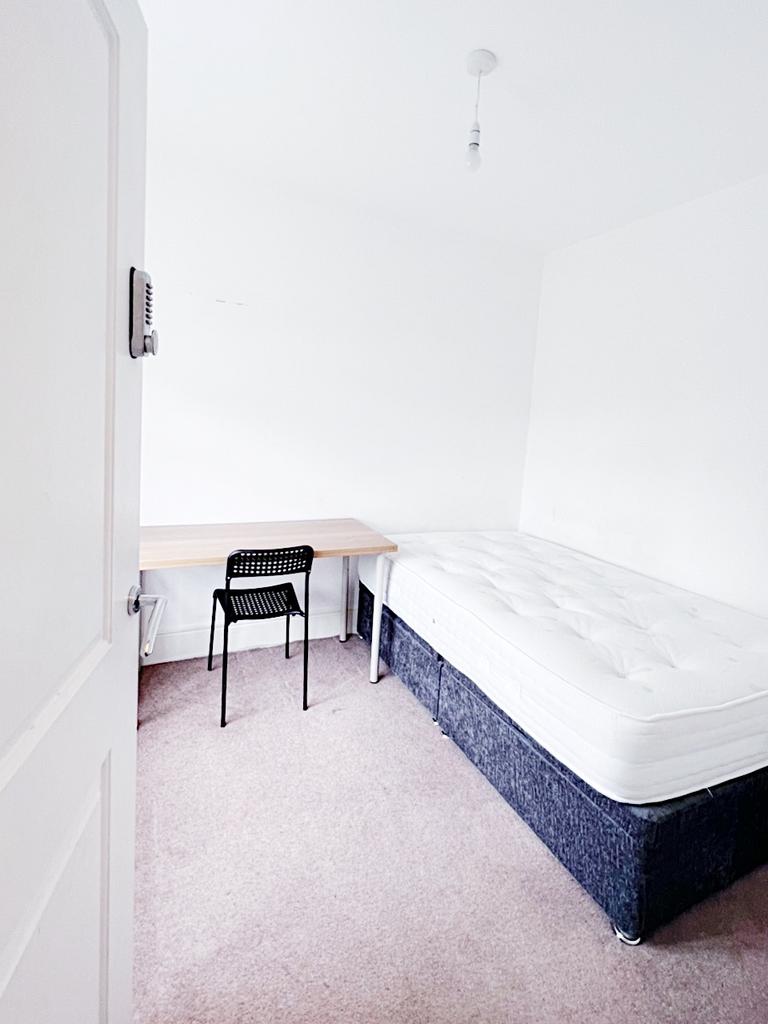 Bright, simply furnished bedroom with a comfort...