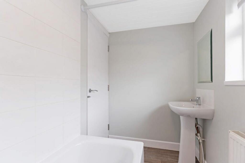 A modern bathroom featuring a sleek bathtub and...