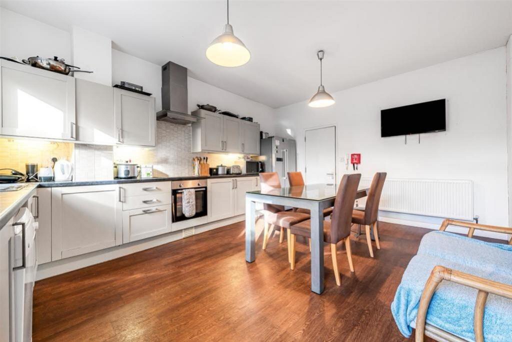 A modern, spacious kitchen featuring sleek cabi...