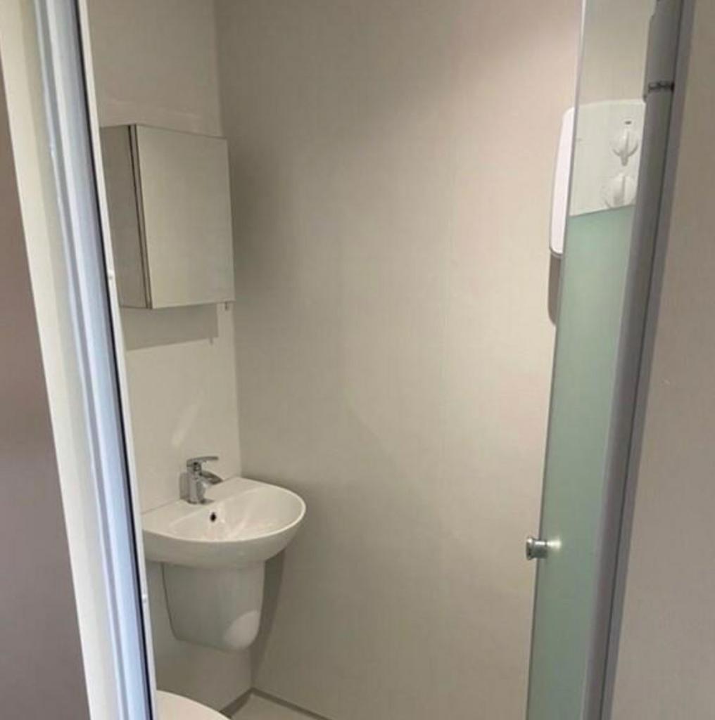 A modern and tidy bathroom with a shower, perfe...