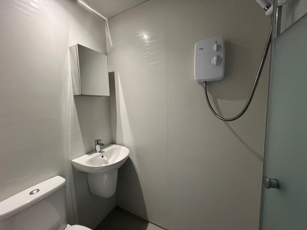 Bright compact bathroom with modern white fitti...