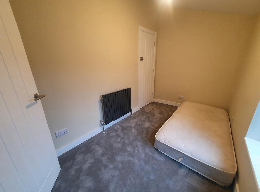 Cozy double bedroom featuring neutral tones, pl...