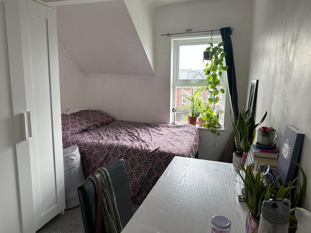 A cozy and well-lit double bedroom featuring a ...