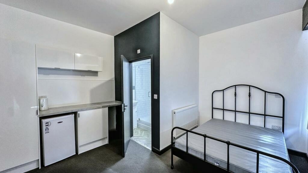 A tidy double bedroom with a functional kitchen...