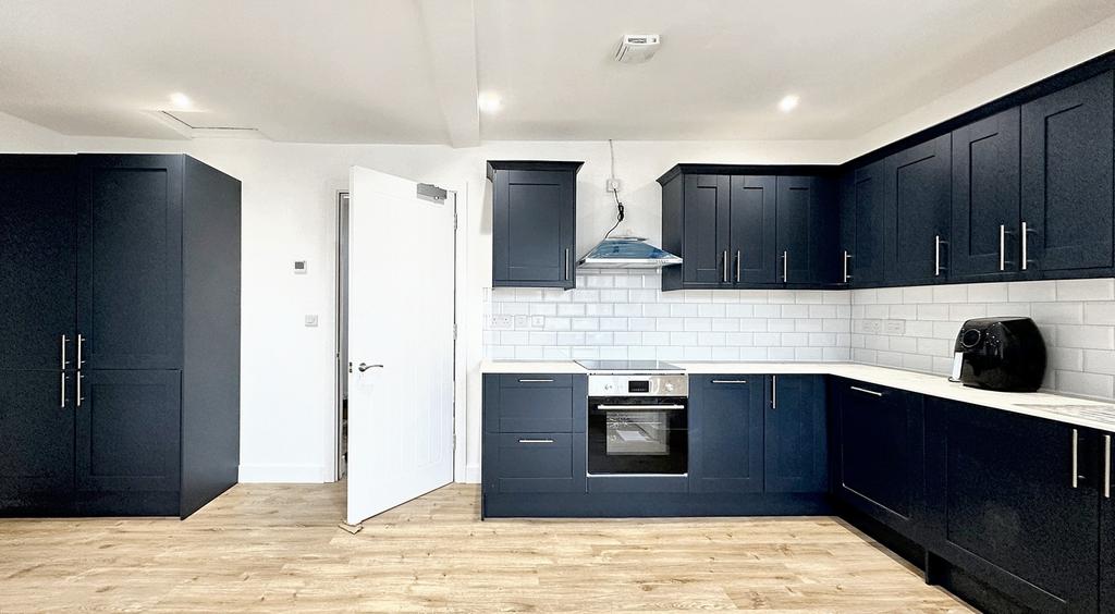 Modern kitchen with sleek navy cabinetry, ample...