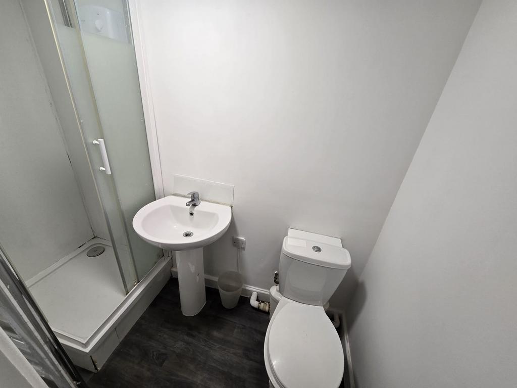 A modern bathroom featuring a shower, sink, and...