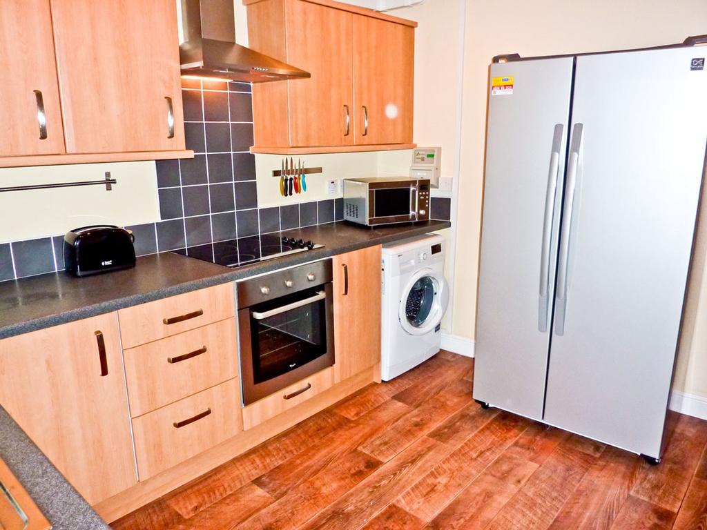 A spacious and modern kitchen equipped with ess...