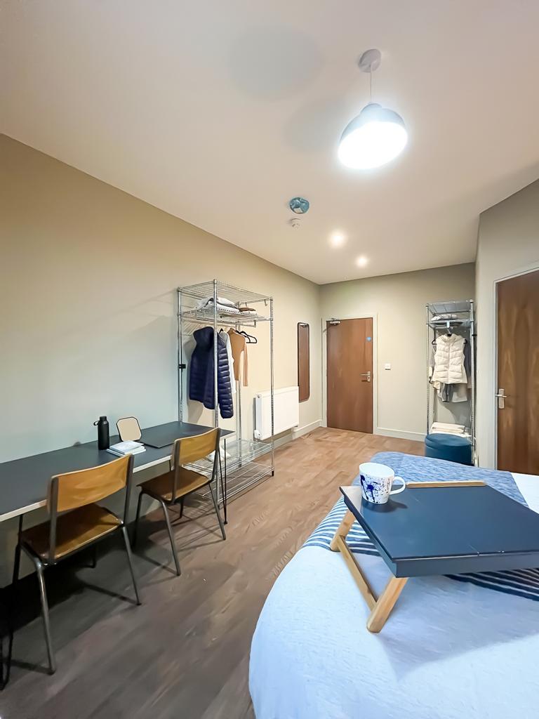 A clean and well-lit double bedroom featuring a...
