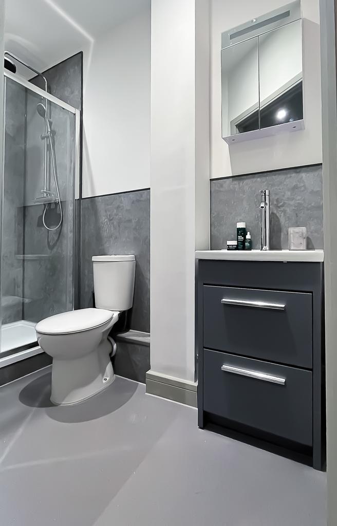 A modern and clean bathroom featuring a shower,...