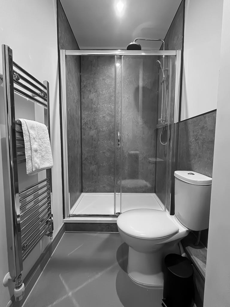 A clean and modern bathroom featuring a shower,...