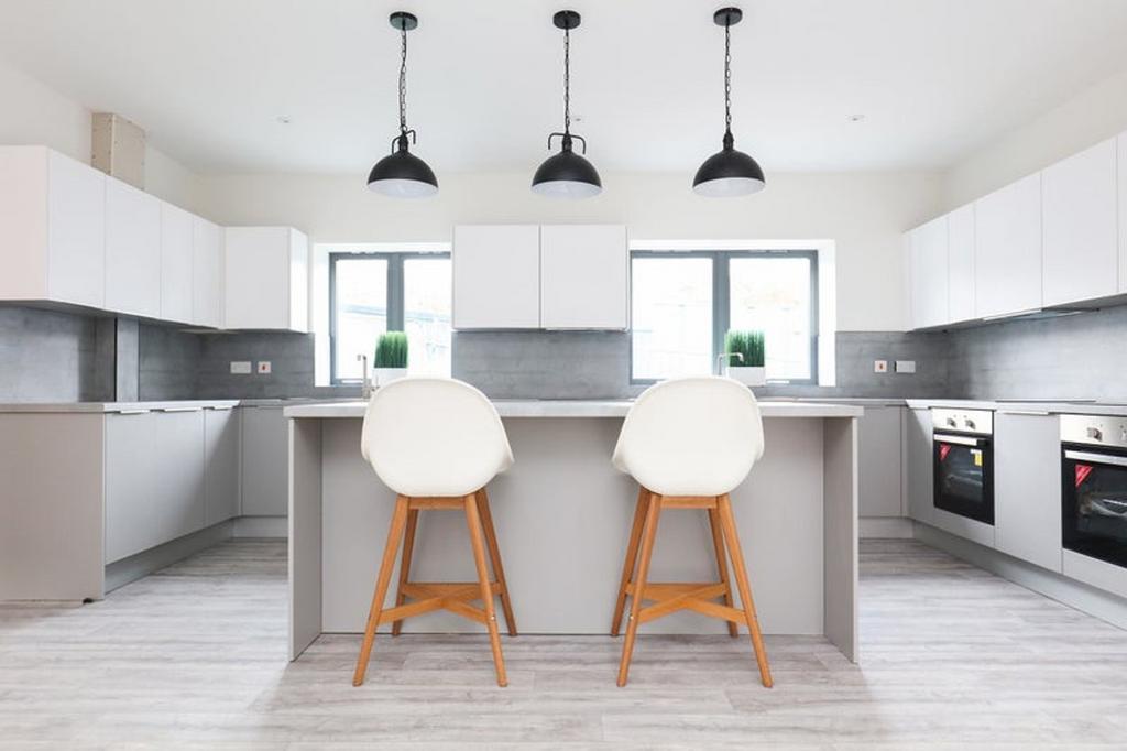 A modern, spacious kitchen featuring sleek cabi...