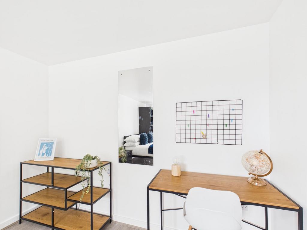 Bright, minimal workspace with a wooden desk, c...