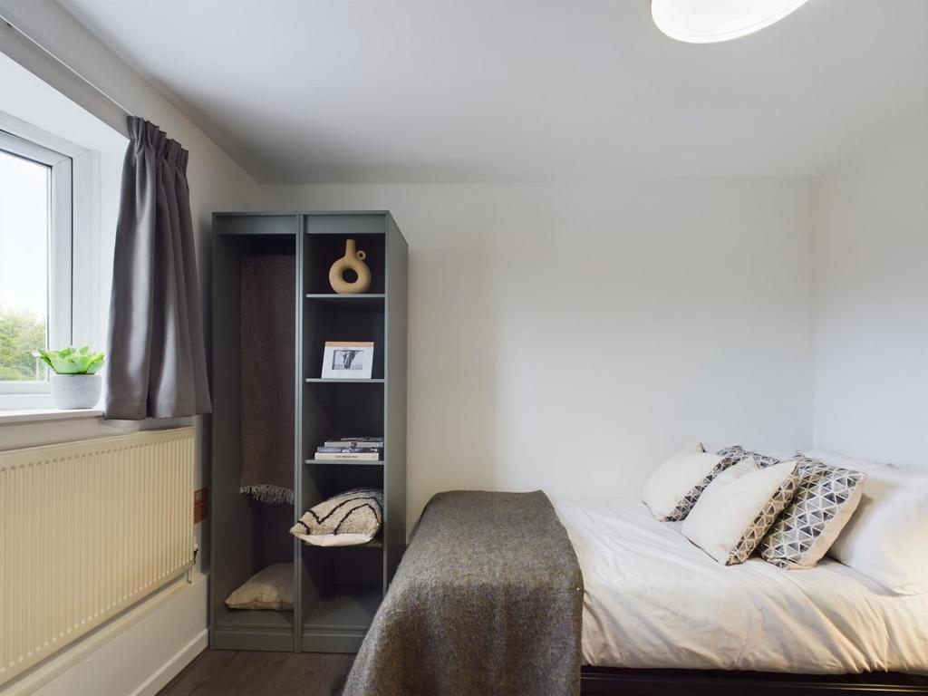 A bright and tidy double bedroom featuring a co...