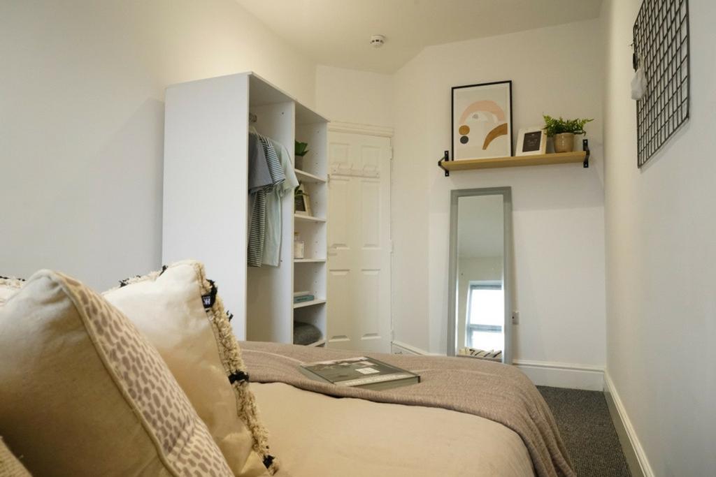 A bright and inviting double bedroom with styli...