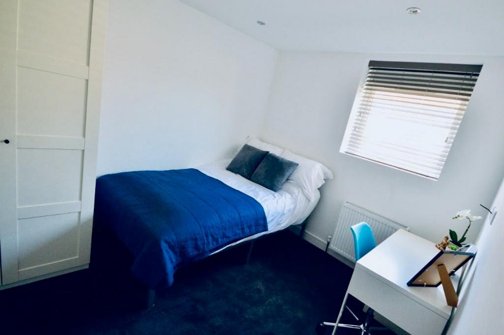 A bright and tidy double bedroom featuring a co...