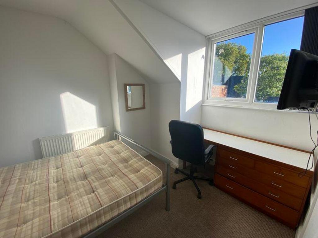 A bright and inviting double bedroom with a com...