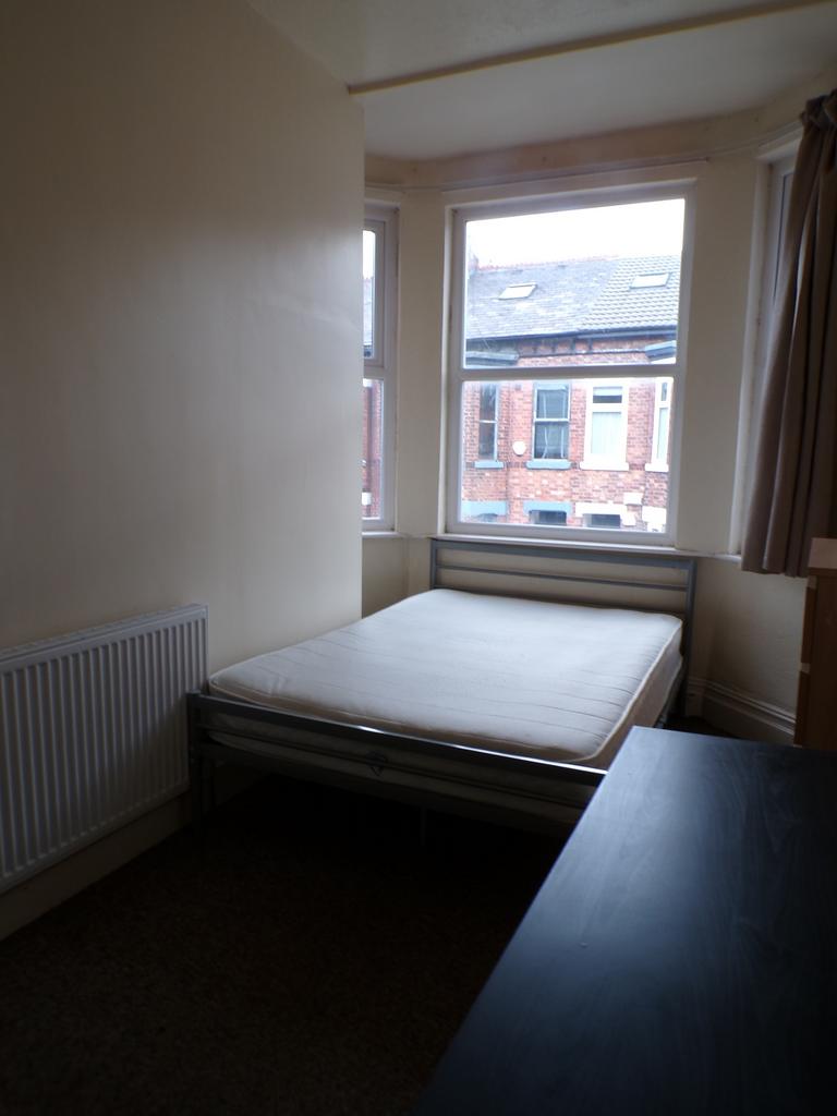 A bright and cozy double bedroom with large win...