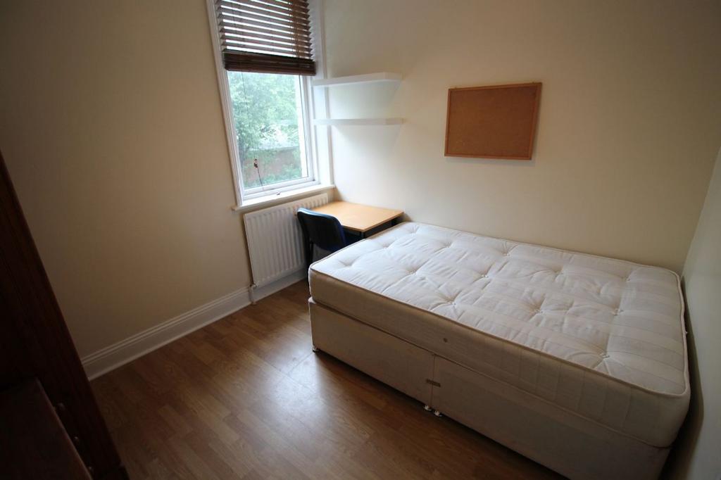 This cozy single bedroom features a comfortable...