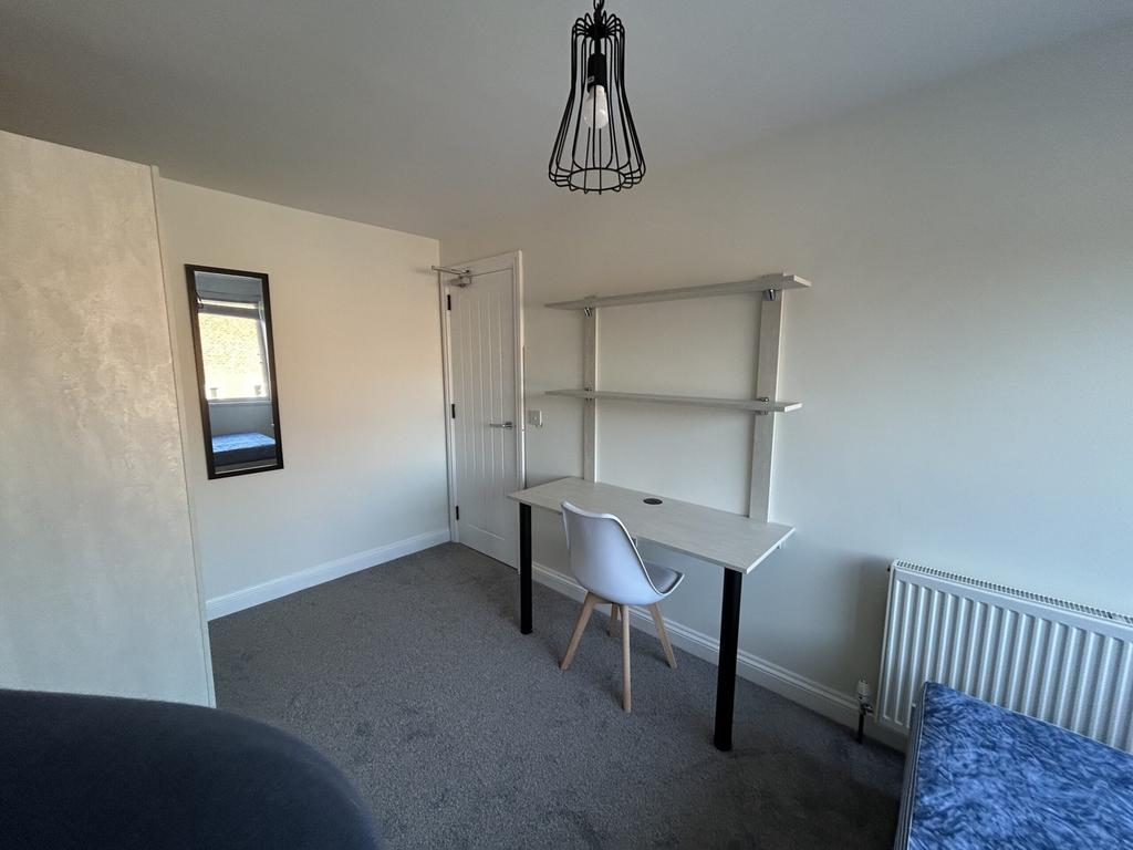 A bright and tidy double bedroom featuring a st...