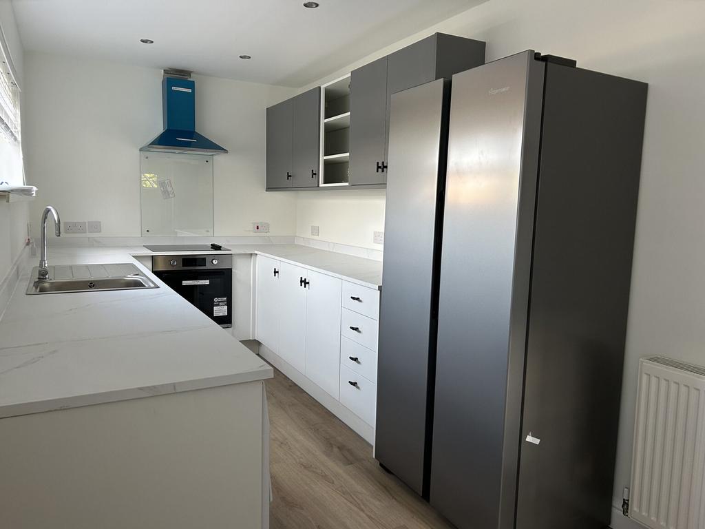 A modern and spacious kitchen featuring ample s...