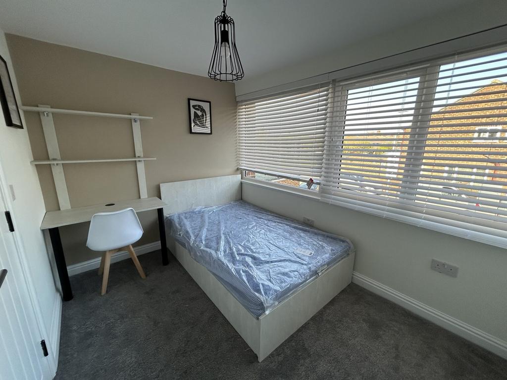 A bright and tidy double bedroom featuring a co...