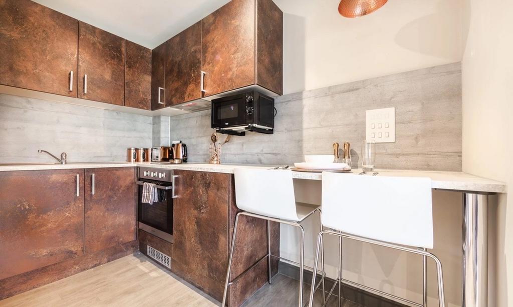 A modern and stylish kitchenette with sleek cab...