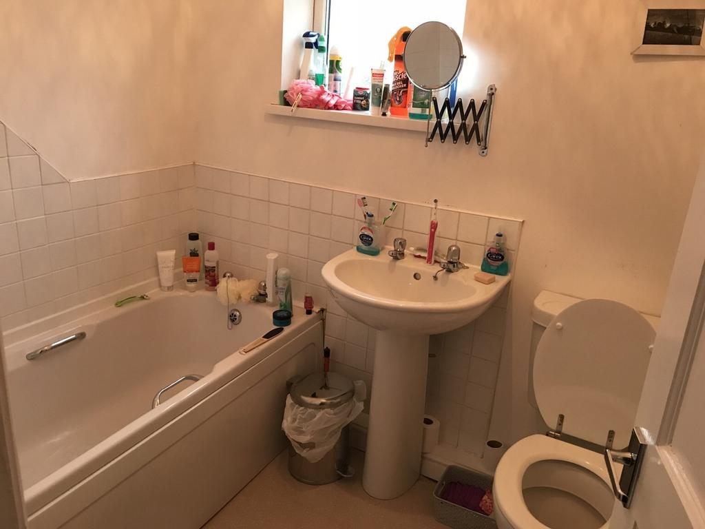 A functional bathroom with a bath and natural l...