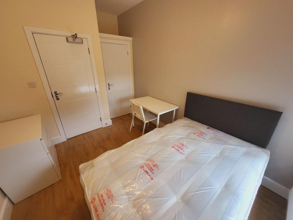This inviting double bedroom features a comfort...