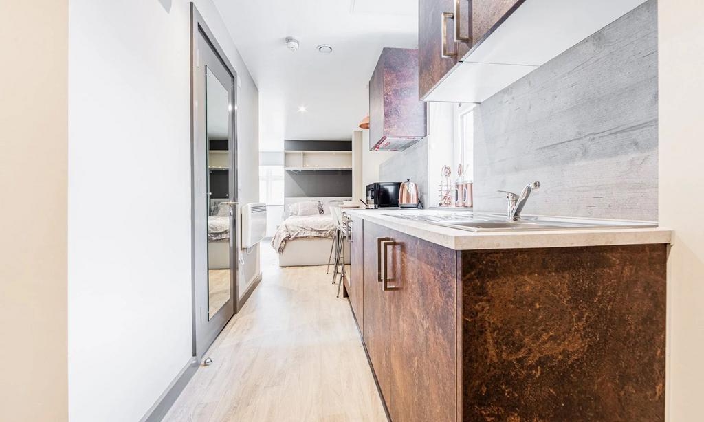 A modern kitchenette featuring sleek cabinetry ...