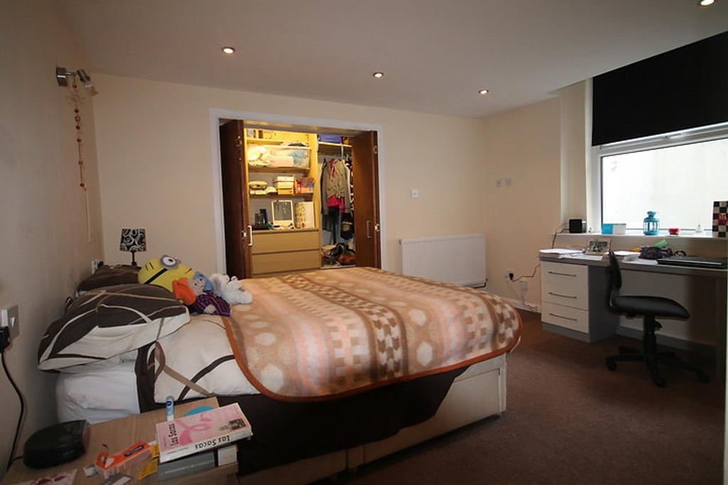 Spacious double bedroom featuring a cozy bed, a...