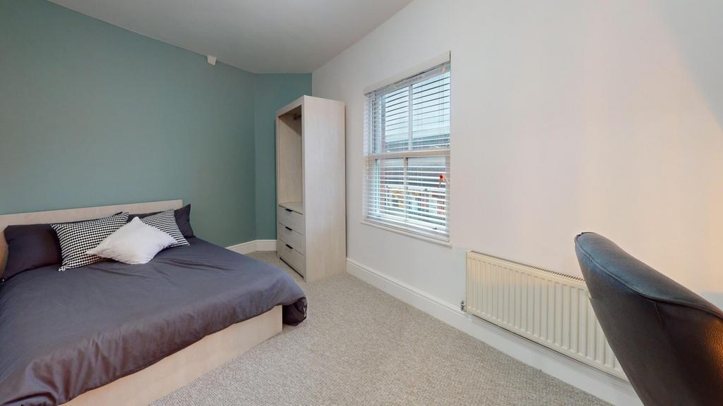 A bright and inviting double bedroom with moder...
