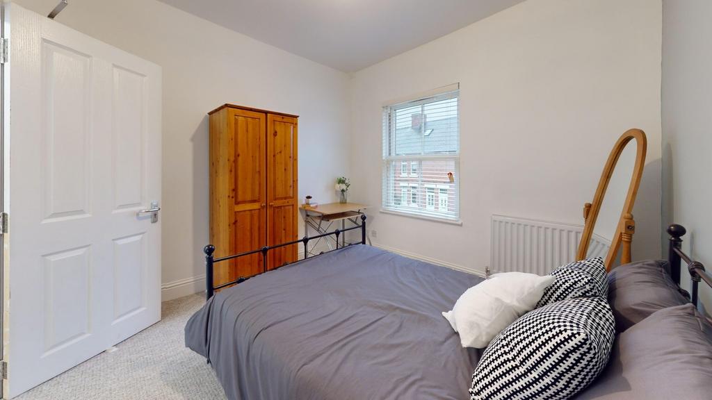 A bright and tidy double bedroom featuring a co...