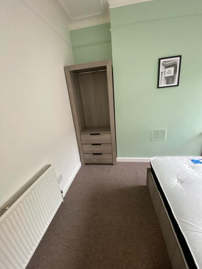 A cozy double bedroom featuring a fitted wardro...
