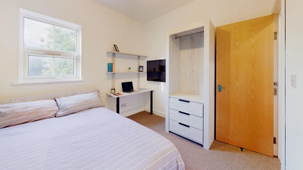 A spacious and bright double bedroom featuring ...