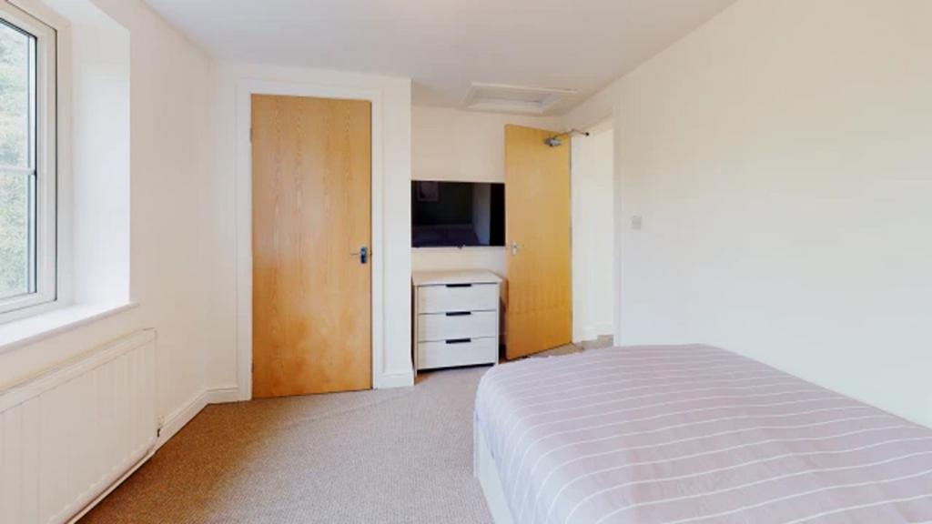A spacious and inviting double bedroom with amp...