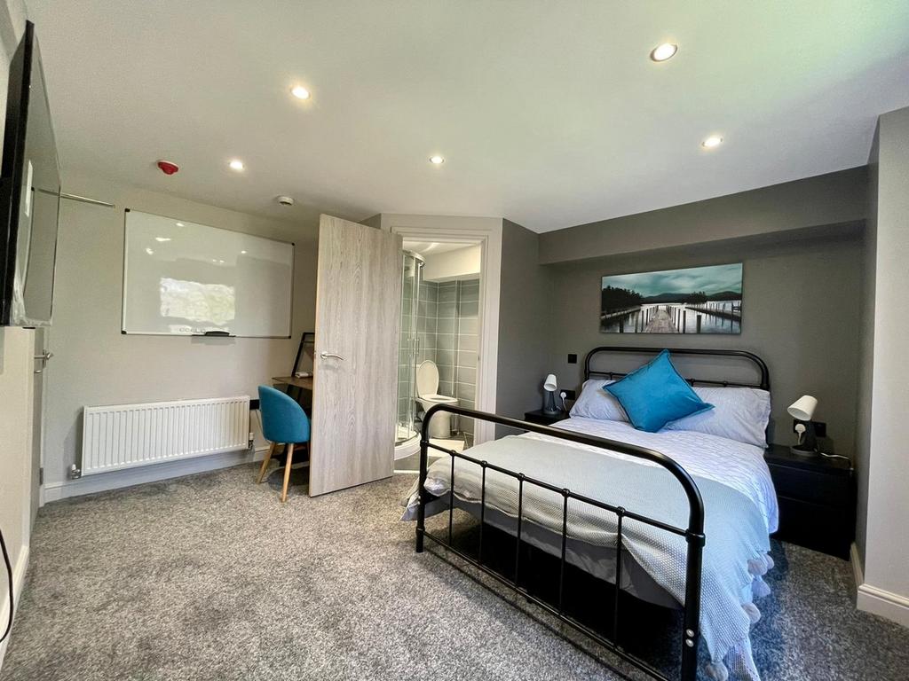 This inviting double bedroom features a comfort...