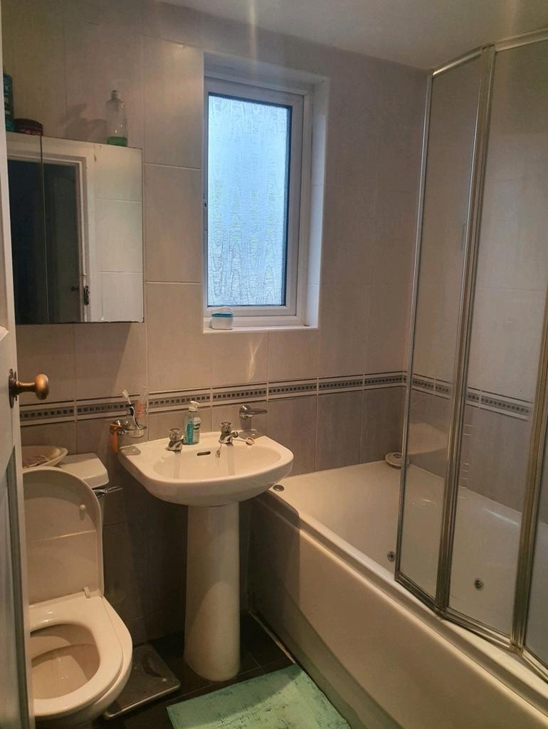A tidy bathroom featuring both a bath and a sho...