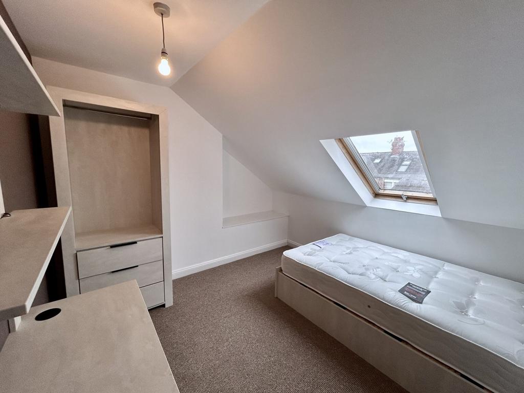 A bright and tidy double bedroom featuring mode...