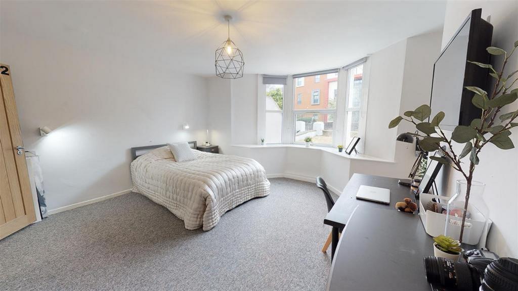 A spacious and well-lit double bedroom featurin...