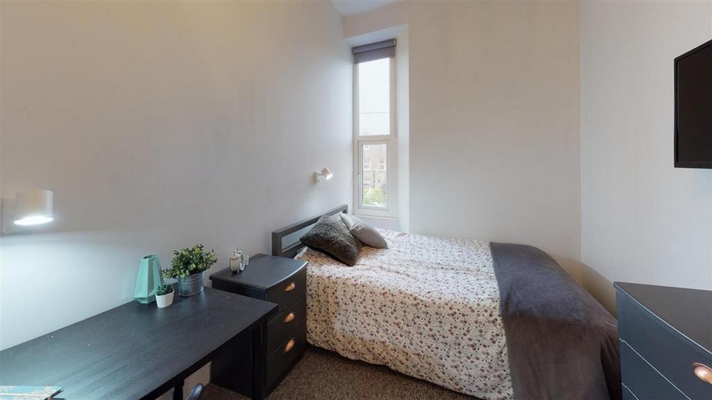 A bright and tidy double bedroom featuring a co...
