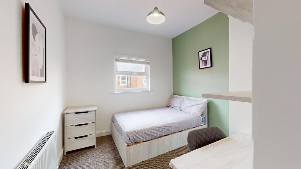 A bright and tidy double bedroom featuring mode...