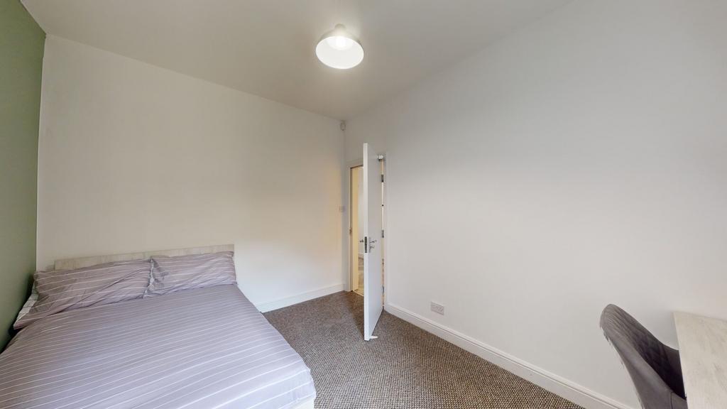 A well-maintained double bedroom featuring comf...