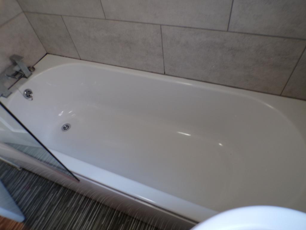 A modern bathroom featuring a sleek bathtub, pe...