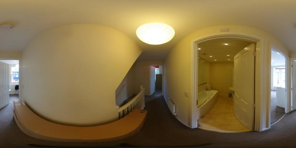A bright and tidy hallway leading to various ro...