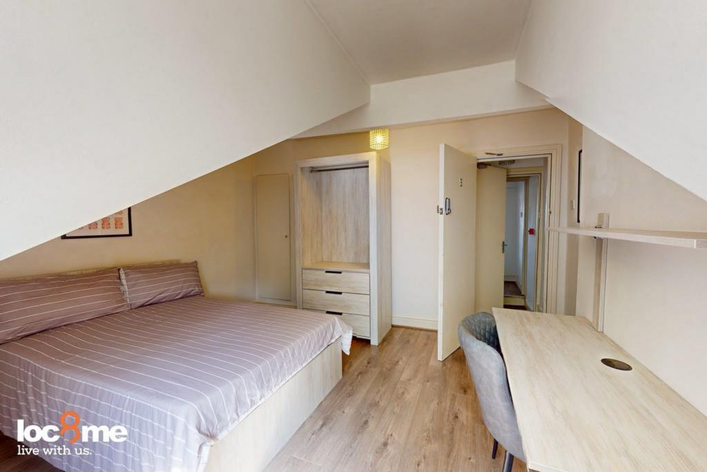 A bright and tidy double bedroom featuring a co...