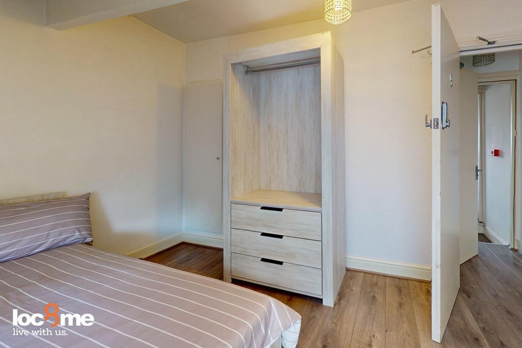 A bright and inviting double bedroom with styli...