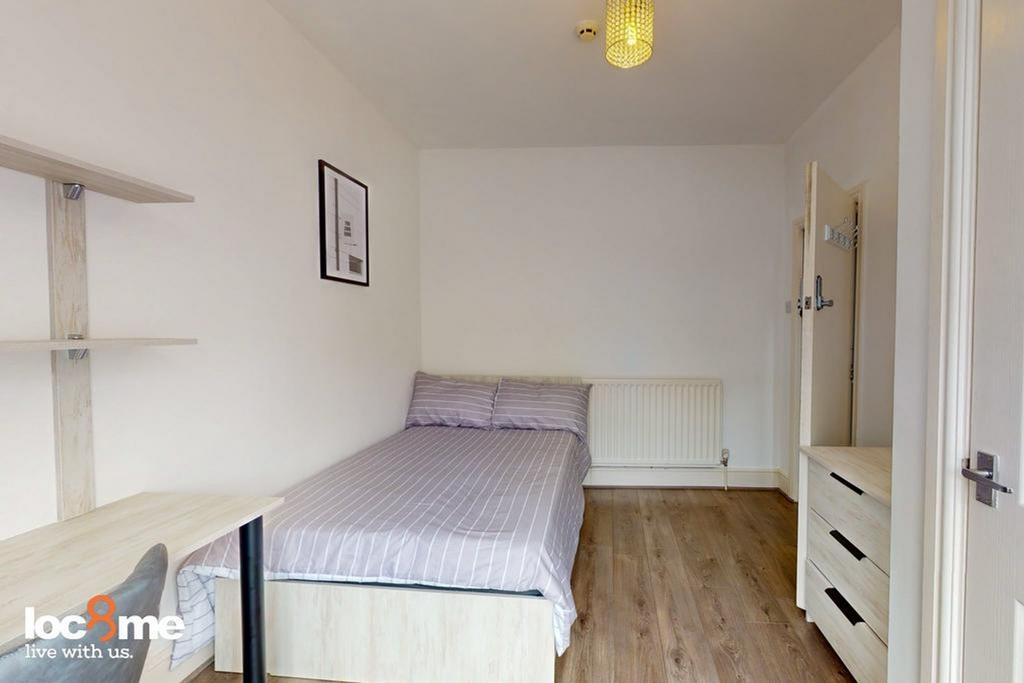 A cozy and neatly arranged double bedroom, perf...