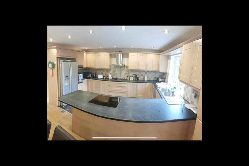 Spacious and modern kitchen featuring ample cou...