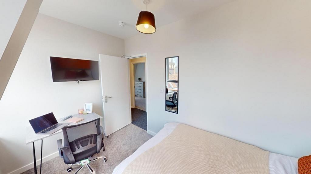 A bright and inviting double bedroom with a com...